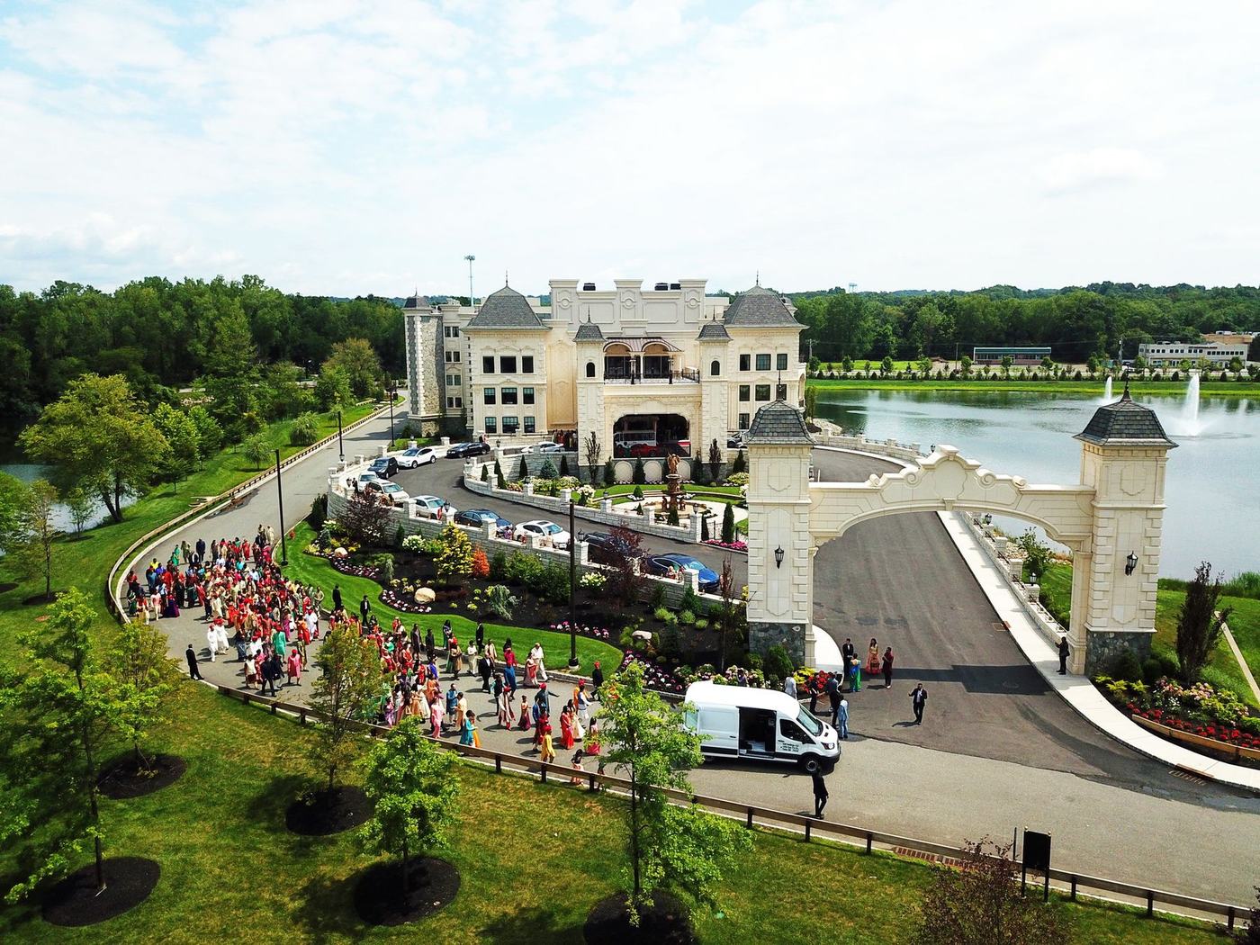 Aerial view of the baraat arriving at The Legacy Castle beside its lake