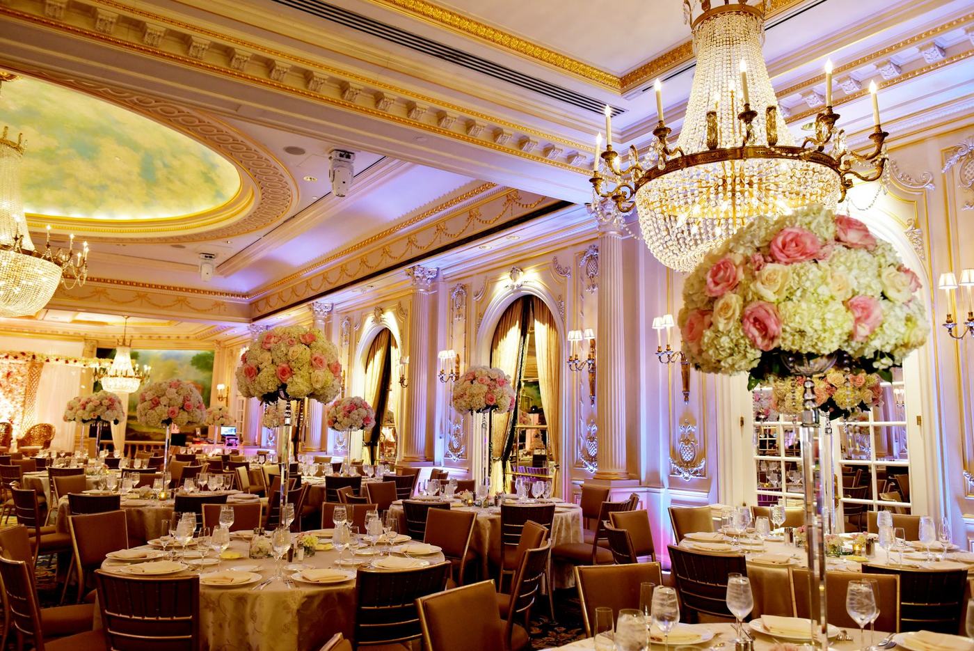 Ballroom tables with tall florals under the painted ceiling