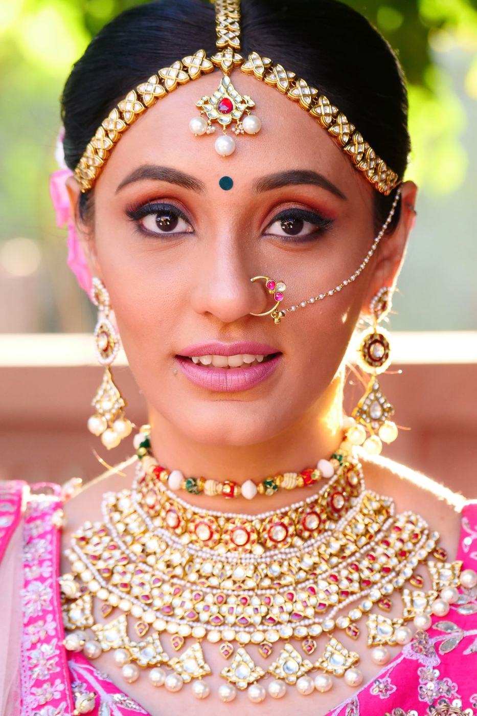 Bride in pink wearing a kundan choker and maang tikka