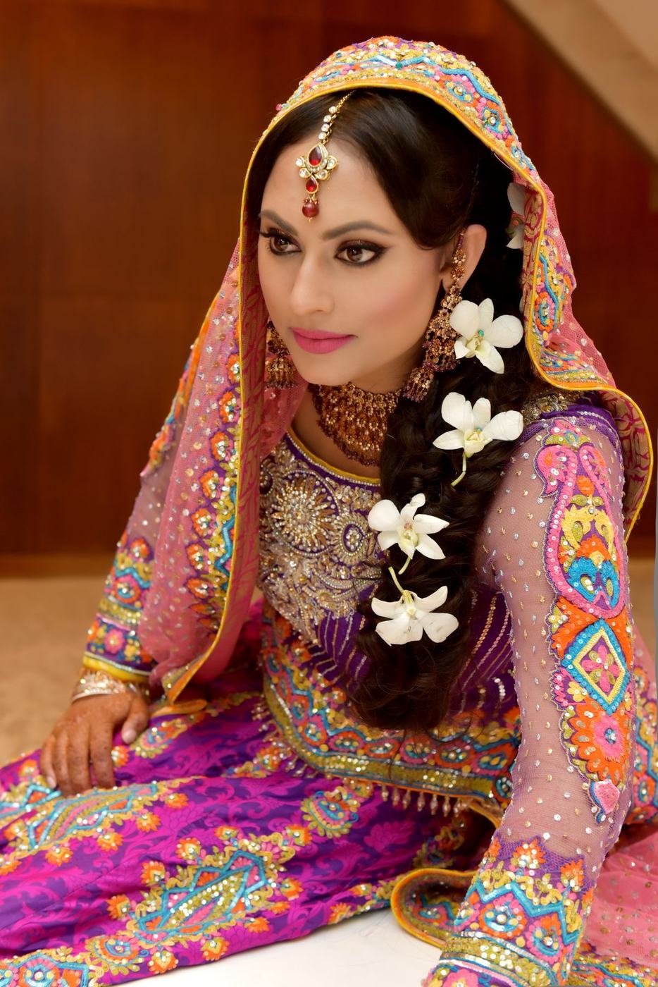 Bride in purple and magenta with white flowers in her hair