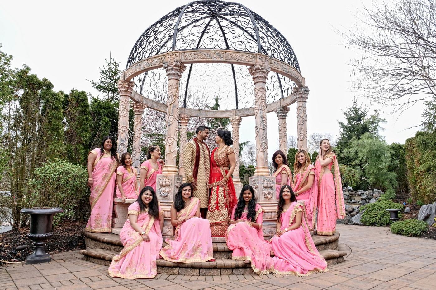 Bride and groom with the bridesmaids in pink at The Imperia gazebo