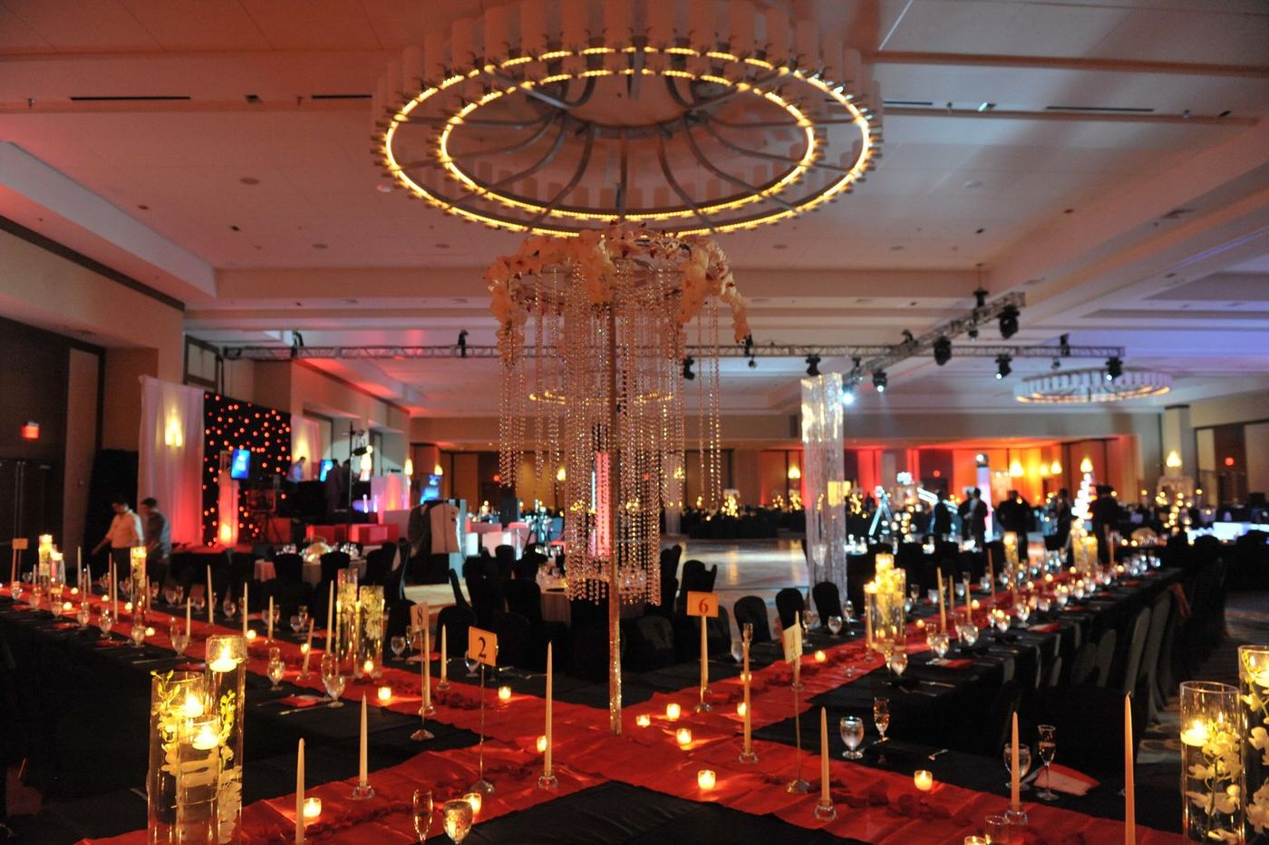 Candlelit reception tables beneath a ring chandelier