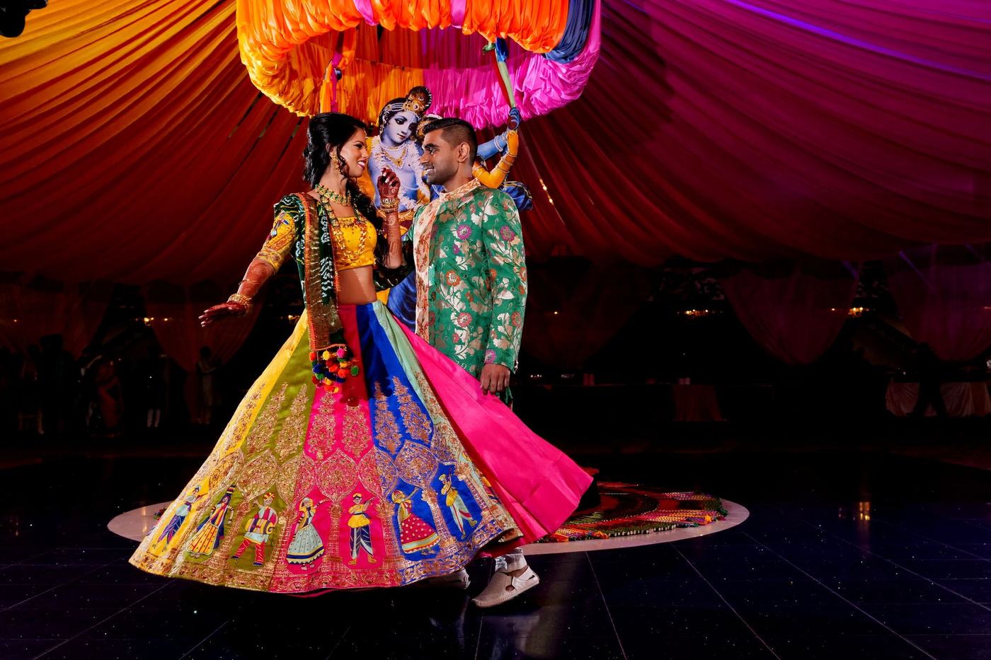 Couple dancing under a draped pink tent at their sangeet