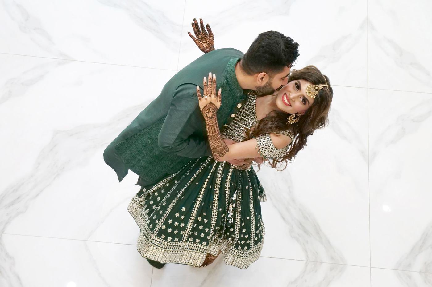 Couple in green seen from above on a white marble floor