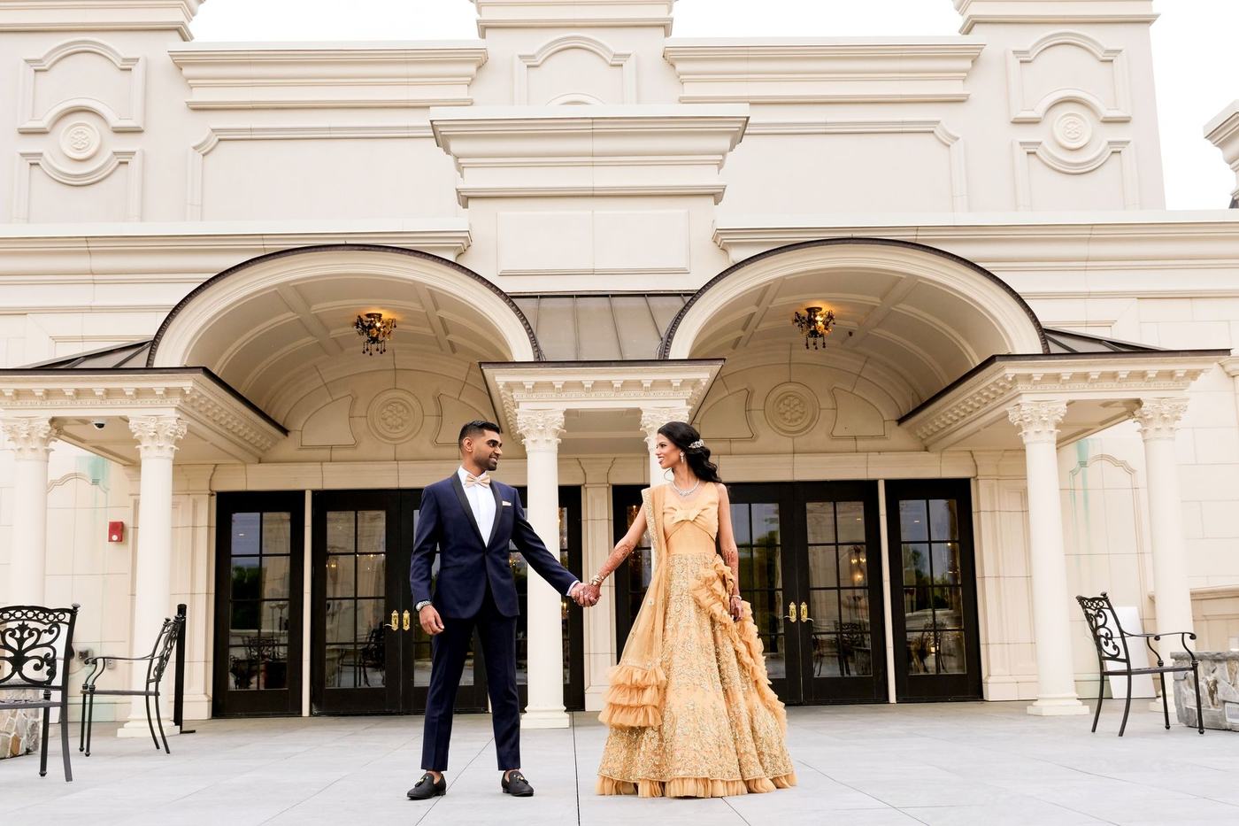 Couple hand in hand before the white facade of Park Chateau Estate