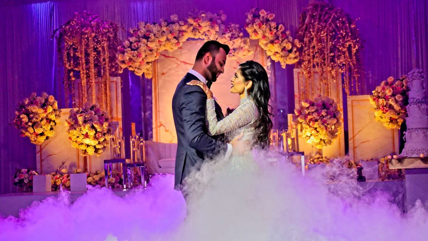 Couple in purple smoke before the floral reception stage