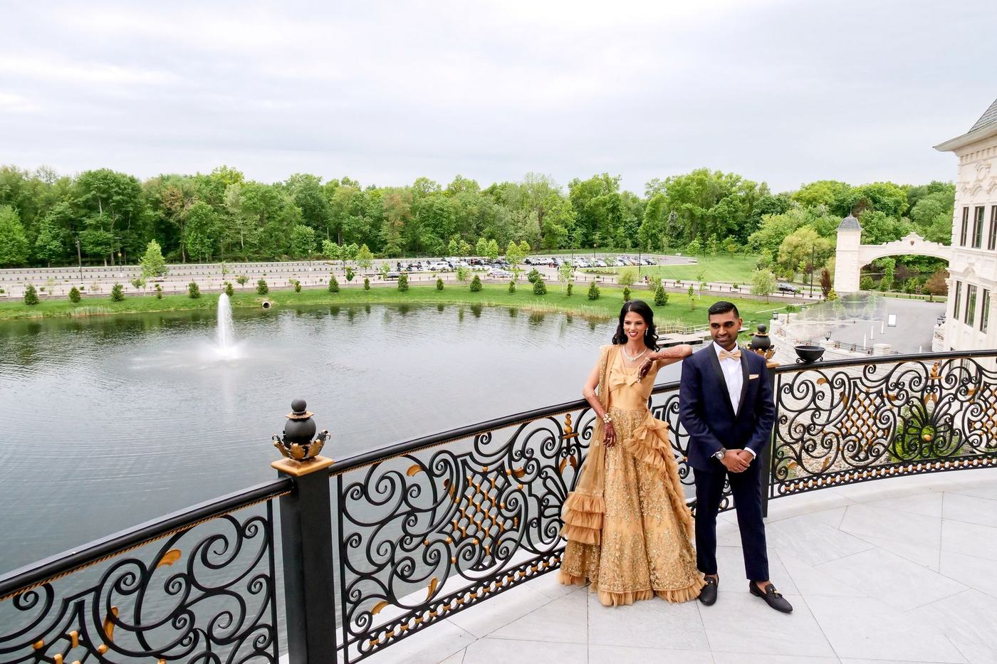 Couple on a balcony above the lake and fountain at Park Chateau Estate