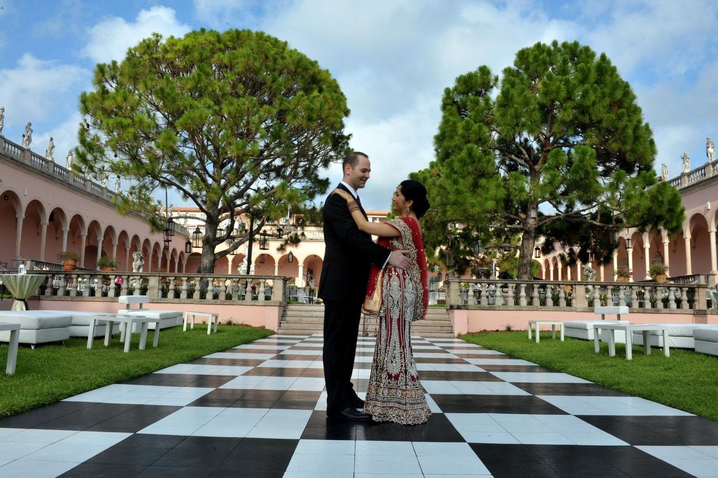 Couple on a checkerboard garden terrace between clipped trees