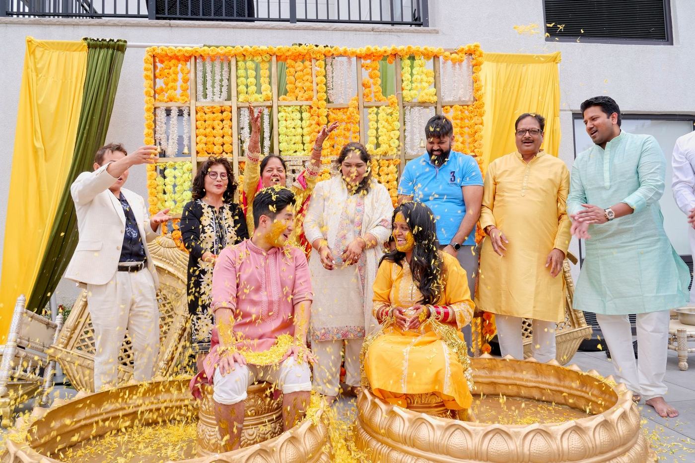 Family gathered in yellow around the couple for the haldi ceremony