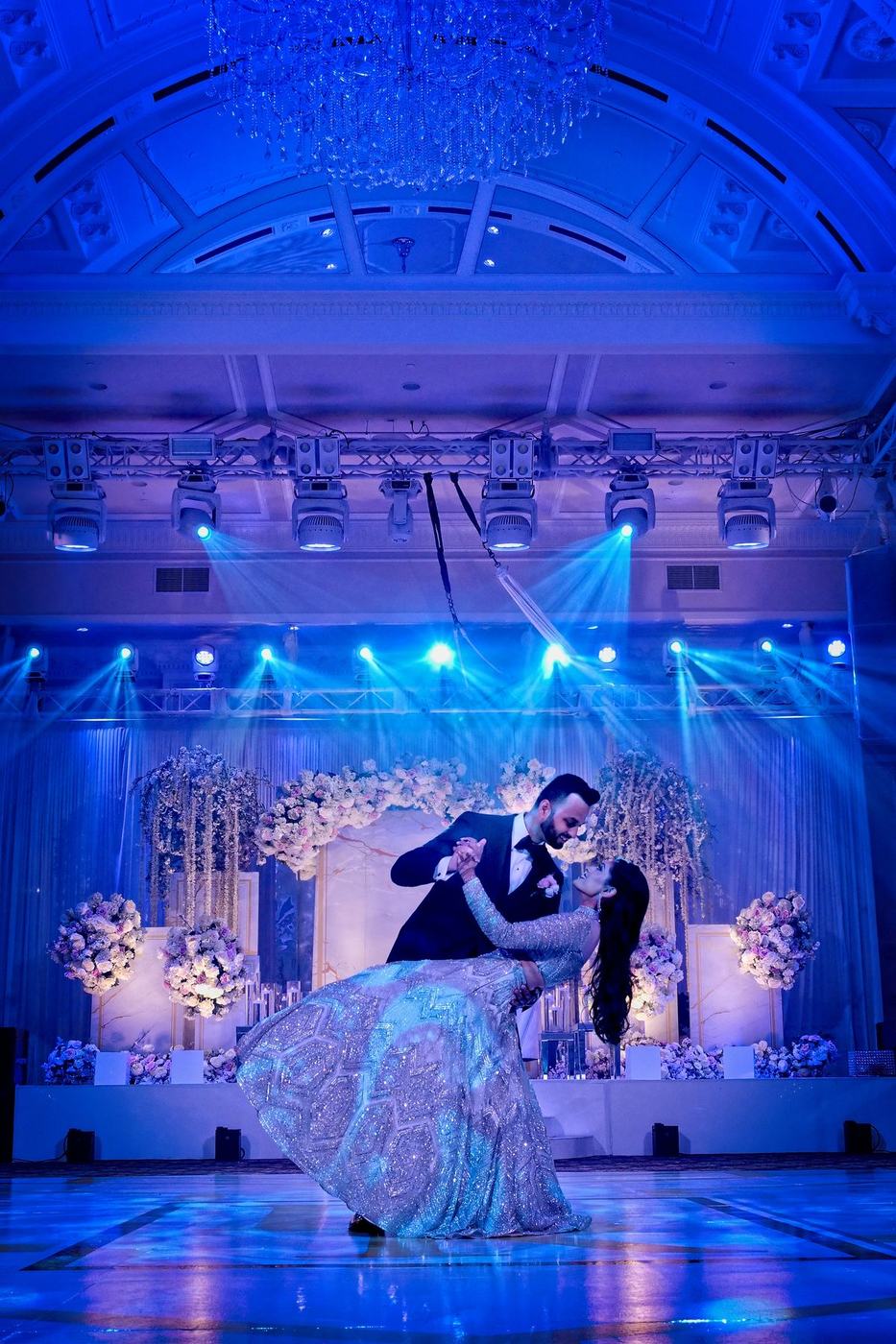 First dance dip under the ballroom's blue light