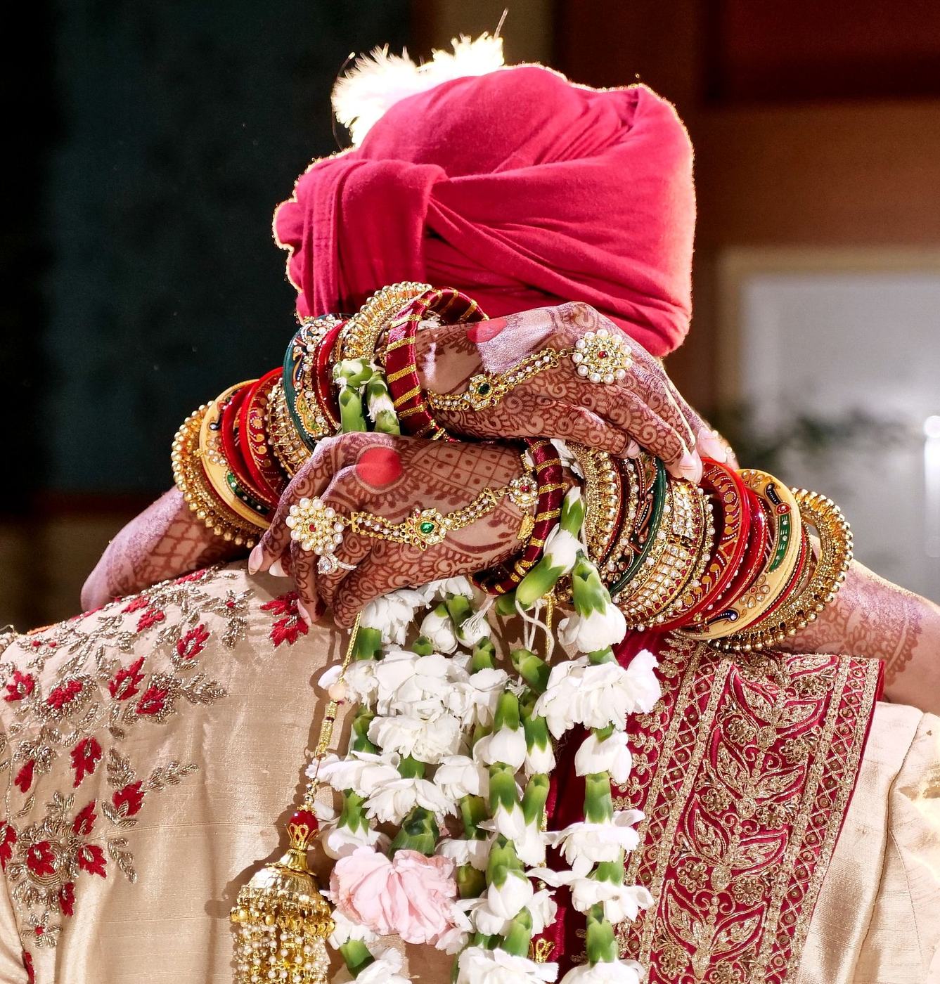 Groom from behind with his rose garland and red turban