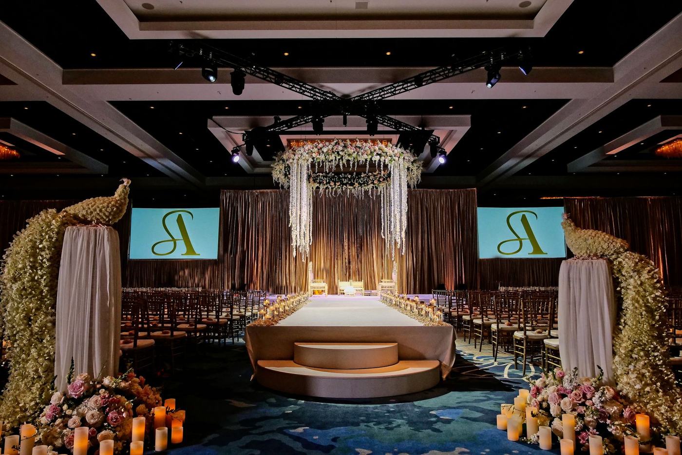 Hilton Orlando reception stage with monogram screens and florals