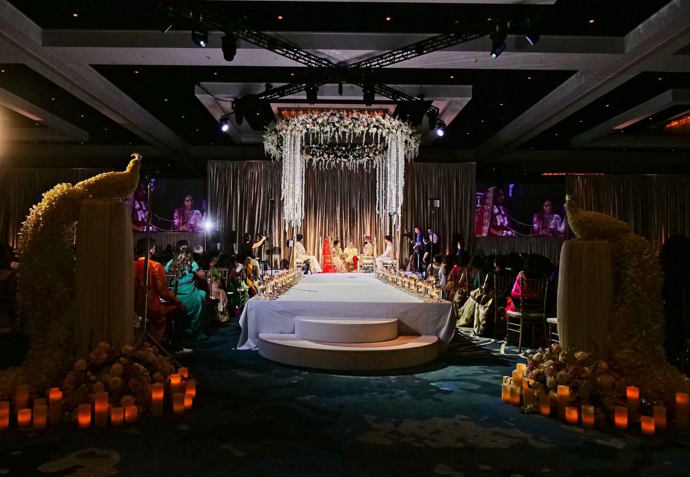 Mandap at night ringed with candles in the Hilton Orlando ballroom