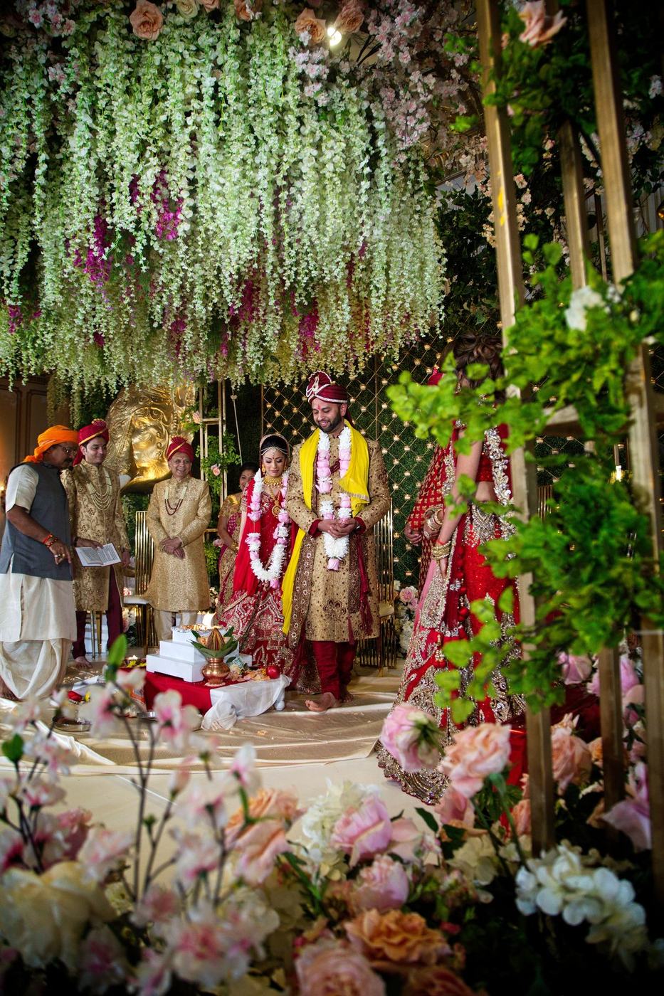 Mandap of hanging wisteria and blossom with the families seated