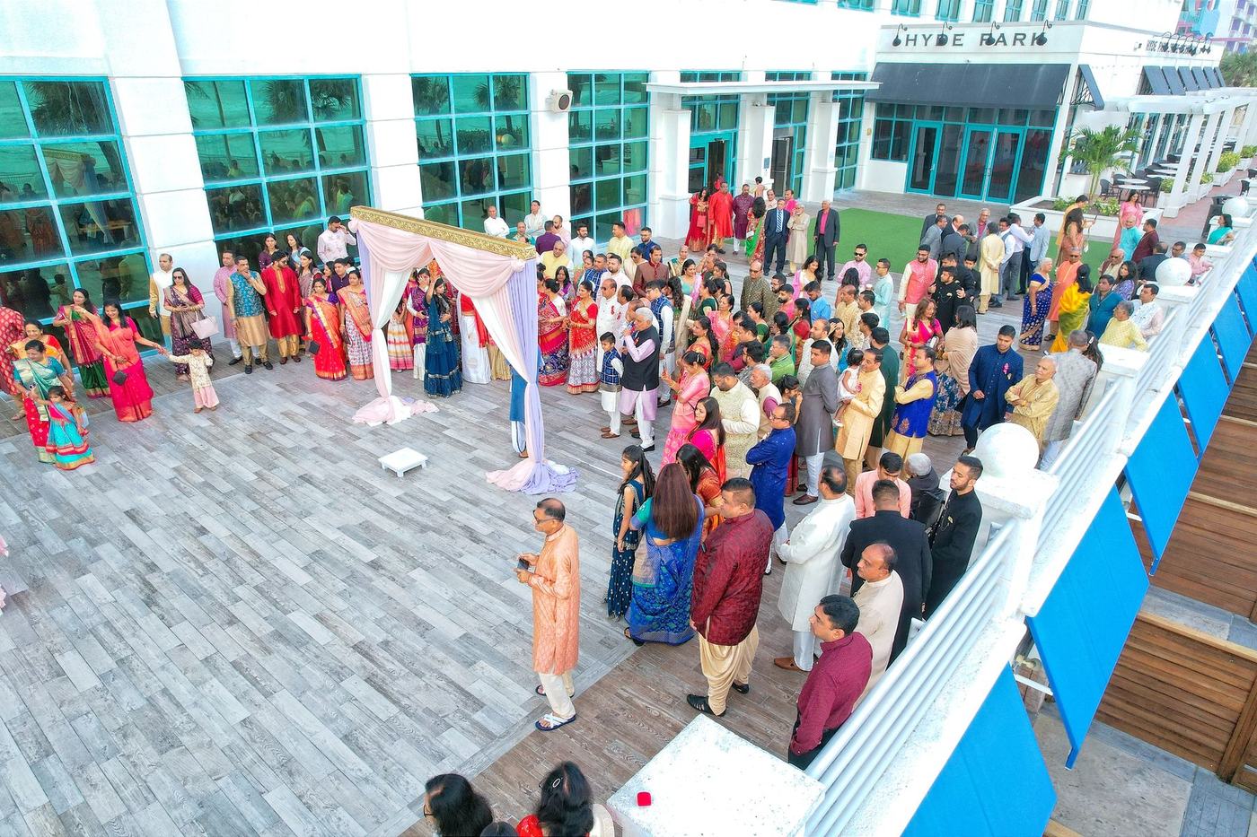Rooftop wedding ceremony seen from above, guests gathered around the mandap
