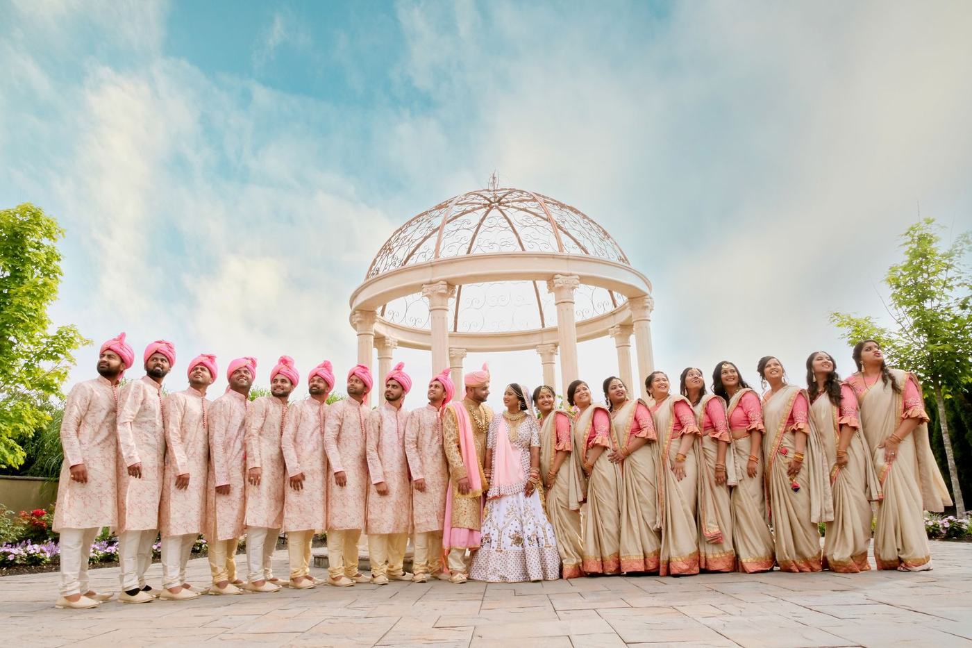Wedding party in pink and cream lined up at the gazebo